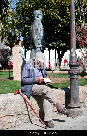 Alter Mann lesen entspannen im Park neben der Statue von Blas Infante in Ronda, Provinz Malaga, Andalusien, Spanien Stockfoto