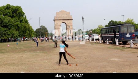 Eine Mädchen spielt Cricket im Schatten des India Gate. Ein typischer sieht Sonntag Horden von Menschen spielen auf jeder freie Stück Land. Stockfoto