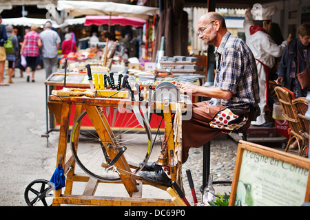 Mann, die Messer in einem französischen Markt schärfen Stockfoto