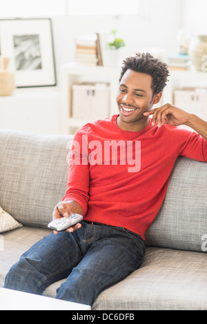 Mann auf Sofa sitzen und Fernsehen Stockfoto