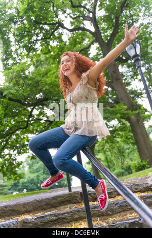 USA, New York, New York City, Central Park, Frau gleiten auf Geländer im park Stockfoto