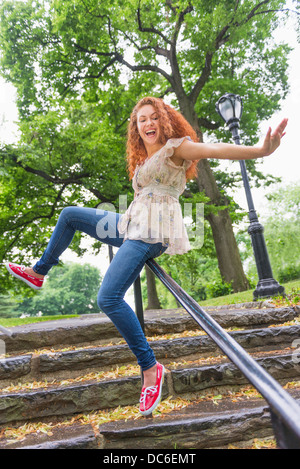 USA, New York, New York City, Central Park, Frau gleiten auf Geländer im park Stockfoto