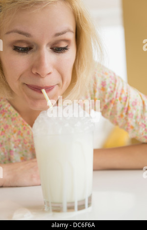 Porträt der Frau bläst Seifenblasen in Milch Stockfoto