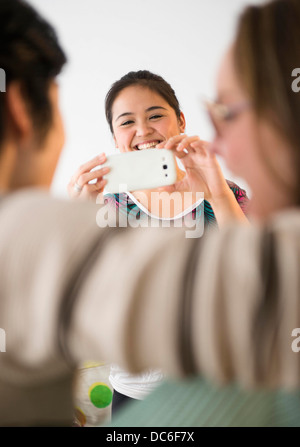 Junge Frau unter Bild mit Handy Stockfoto