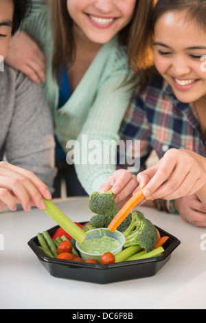 Junge Frauen und Menschen essen frisches Gemüse Stockfoto