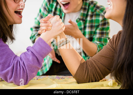 Junge Frauen und Mann arm wrestling Stockfoto