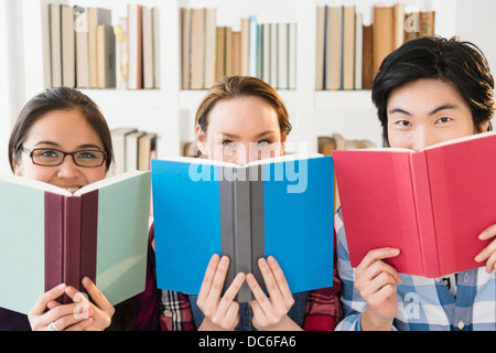 Junge Frauen und Mann gespickt in Bibliothek Stockfoto