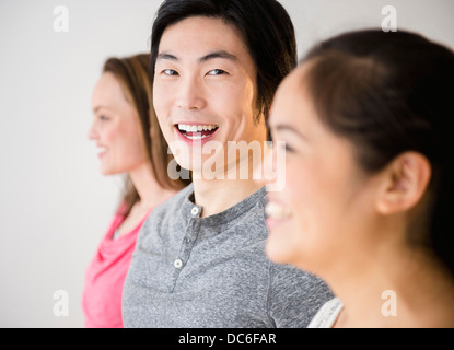 Porträt des jungen Mannes stehend zwischen jungen Frauen Stockfoto