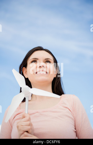 Porträt der jungen Frau mit Miniatur-Windkraftanlage Stockfoto