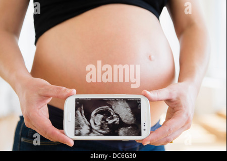Mittleren Bereich schwangere Frau mit Handy Stockfoto