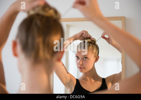 Rückansicht der Teenager (16-17) Ballerina Spiegel untersucht und ihr Haar-styling Stockfoto