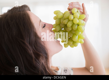 Porträt der jungen Frau essen Trauben Stockfoto