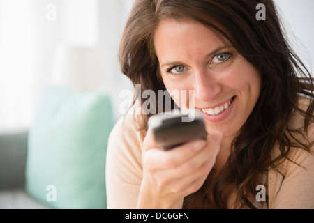 Junge Frau Betrieb Fernbedienung Stockfoto