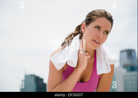 USA, New Jersey, Jersey City, Porträt der jungen Frau, die ihren Puls überprüfen Stockfoto