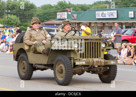 Zwei Männer gekleidet als WW2 GIs einen Vintage Jeep fahren. Stockfoto