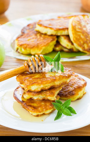 süße Pfannkuchen mit Äpfeln und Honig auf einem Teller Stockfoto