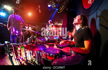 Leistungen der Musiker, der Schlagzeuger im Vordergrund, Rock-Musik-Konzert Stockfoto