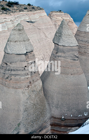 Ein Zelt Rock Formation Kegel von weichen Bimsstein unter schwerer Deckgestein im Kasha-Katuwe Zelt Rocks National Monument 8. Februar 2010 in der Nähe von Cochiti, New Mexico. Das Gebiet verdankt seine bemerkenswerte Geologie Schichten aus vulkanischem Gestein und Asche abgelagerten pyroklastischer Strom aus einer vulkanischen Explosion innerhalb der Jemez Vulkanfeldes, die 6 bis 7 Millionen Jahren aufgetreten sind. Im Laufe der Zeit schuf Verwitterung und Abtragung dieser Schichten Schluchten und Zelt Felsen. Stockfoto