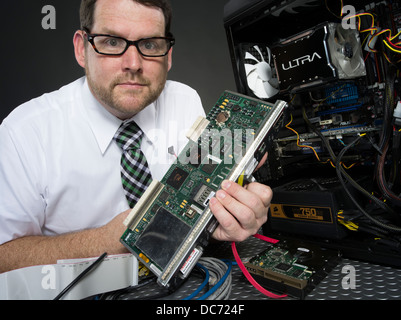 Mann mit Computer und verschiedenen Hardware-Komponenten Stockfoto