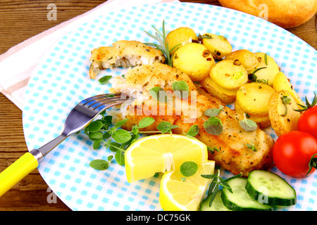 Paniertes Fischfilet mit Rosmarinkartoffeln und Gemüse, Nahaufnahme Stockfoto