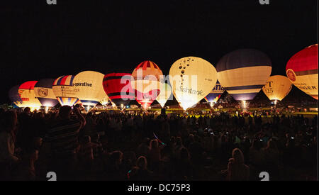 Luftballons an der 35. UK Bristol Balloon Fiesta am Hofe Ashton Nightglow in der ersten Nacht am 8. August 2013 beleuchtet mit ihren Brennern zur Begleitung von Musik von einem riesigen Publikum beobachtet Stockfoto