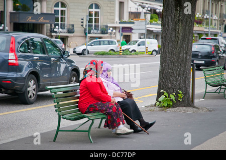 Zwei muslimische Frauen sitzen auf einer Bank auf den Straßen von Genf, Schweiz, Europa Stockfoto