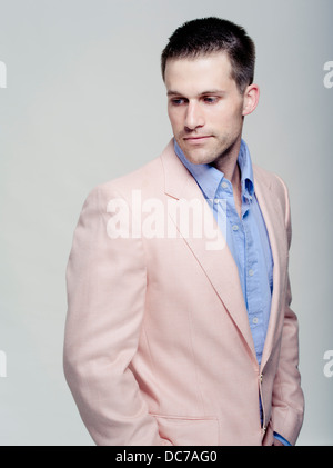 Gut aussehend kaukasischen Mann in seinem tragen babyblauen Shirt und rosa Jacke Stockfoto