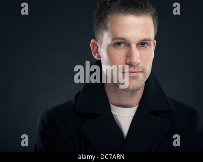 Hübscher kaukasischen Mann in weißem T-shirt und dunklen Wollmantel Erbse (Jacke) Stockfoto