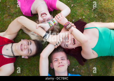 Vier Jugendliche sind auf dem Rasen austoben. Stockfoto