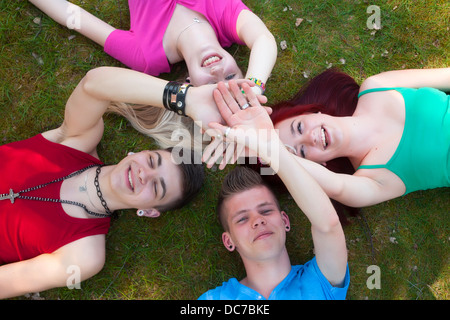 Vier Jugendliche sind auf dem Rasen austoben. Stockfoto