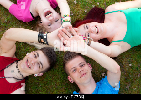 Vier Jugendliche sind auf dem Rasen austoben. Stockfoto