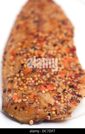 Geräucherte Makrele mit Pfefferkörner und Senfkörner auf einem weißen Teller Stockfoto