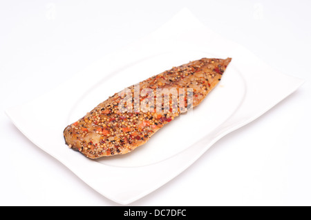 Geräucherte Makrele mit Pfefferkörner und Senfkörner auf einem weißen Teller Stockfoto