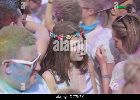 Mädchen in blau Holi Farbe Pulver Farbe Spaß bedeckt begeistern Gig Festival Lachen bedeckt Gesicht weibliche Frauen lila Stockfoto
