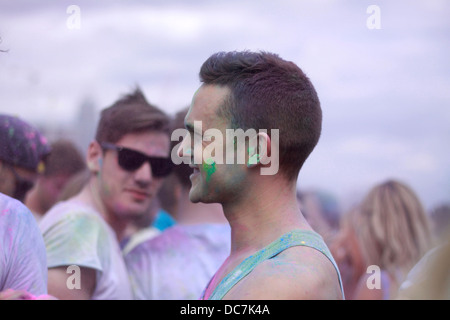 Mädchen in blau Holi Farbe Pulver Farbe Spaß bedeckt begeistern Gig Festival Lachen bedeckt Gesicht männliche Männer schwingen Swag Schattierungen Stockfoto