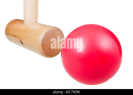 Krocket Holzhammer schlägt rote Kugel schließen sich isoliert auf weißem Hintergrund Stockfoto