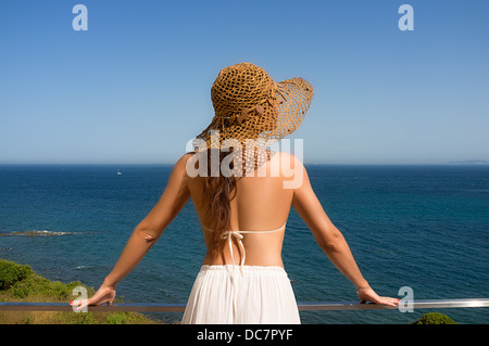 Junge Frau auf einem Hochhaus Balkon mit Blick auf Mittelmeer. Rückwärts Stockfoto