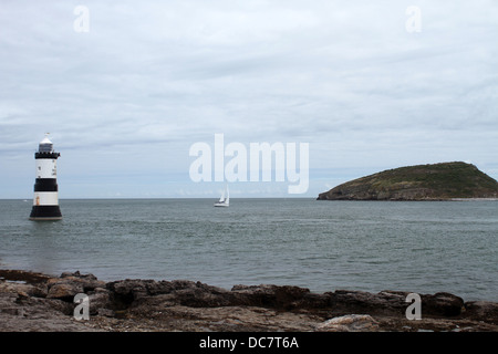 Yacht, zwischen Trwyn Du, oder Schwarzpunkt, Leuchtturm und Puffin Insel Anglesey Wales Stockfoto