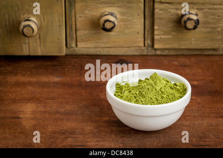 Moringa Blattpulver in einer kleinen Schüssel mit einer rustikalen Schublade Schrank Stockfoto