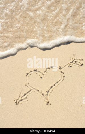Herz mit einem Pfeil an einem Strand in den Sand gezeichnet Stockfoto