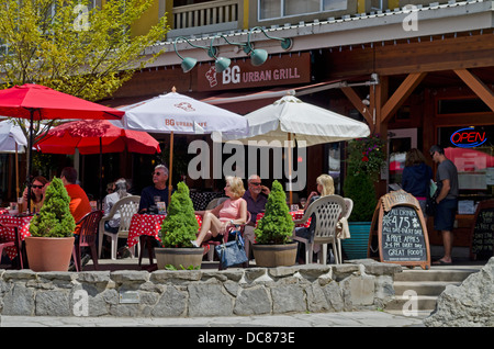 Outdoor-Gäste an Tischen in Restaurants und Cafés in Whistler Village im Sommer.  Unter freiem Himmel im Sommer auf der Terrasse speisen. Stockfoto
