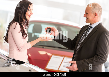 Verkäufer, die Übergabe der Autoschlüssel, lächelnde Frau Stockfoto