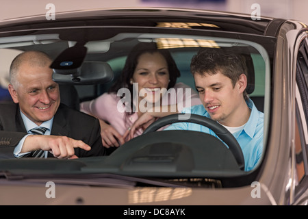 Junges Paar Test Auto im Autohaus Stockfoto