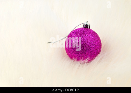 Weihnachtsschmuck - Single Christbaumkugel auf Fell Stockfoto