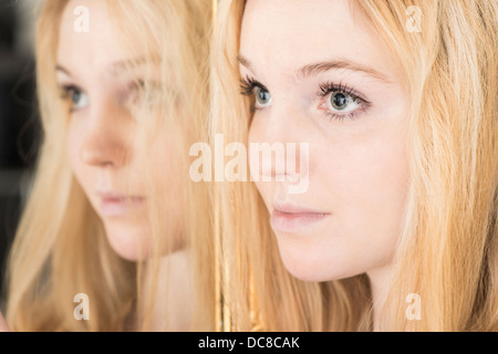 Porträt von blonden weiblichen Jugendlicher durch Spiegel schauen traurig stehen Stockfoto
