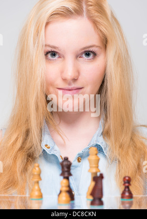 Junge blonde Frau und Schach-Stücke Stockfoto