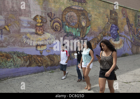 Menschen zu Fuß weitergegeben ein großes Wandgemälde Stillwell Avenue gegenüber der u-Bahnstation auf Coney Island, Brooklyn, NY. Stockfoto