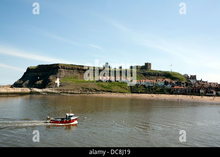 Ein kleines Fischerboot Whitby Hafen, gibt einen kleinen Strand, Häuser und Abtei im Hintergrund. Stockfoto