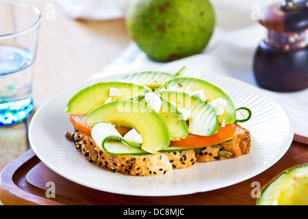 Avocado mit Feta, Gurke und Tomate auf Kürbis und Sesam Brot sandwich Stockfoto