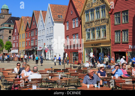 Menschen essen gehen in Outdoor-Straßencafé am Ufer von Bergens historische Holzbauten im Sommer. Bryggen Bergen Norwegen Skandinavien Stockfoto